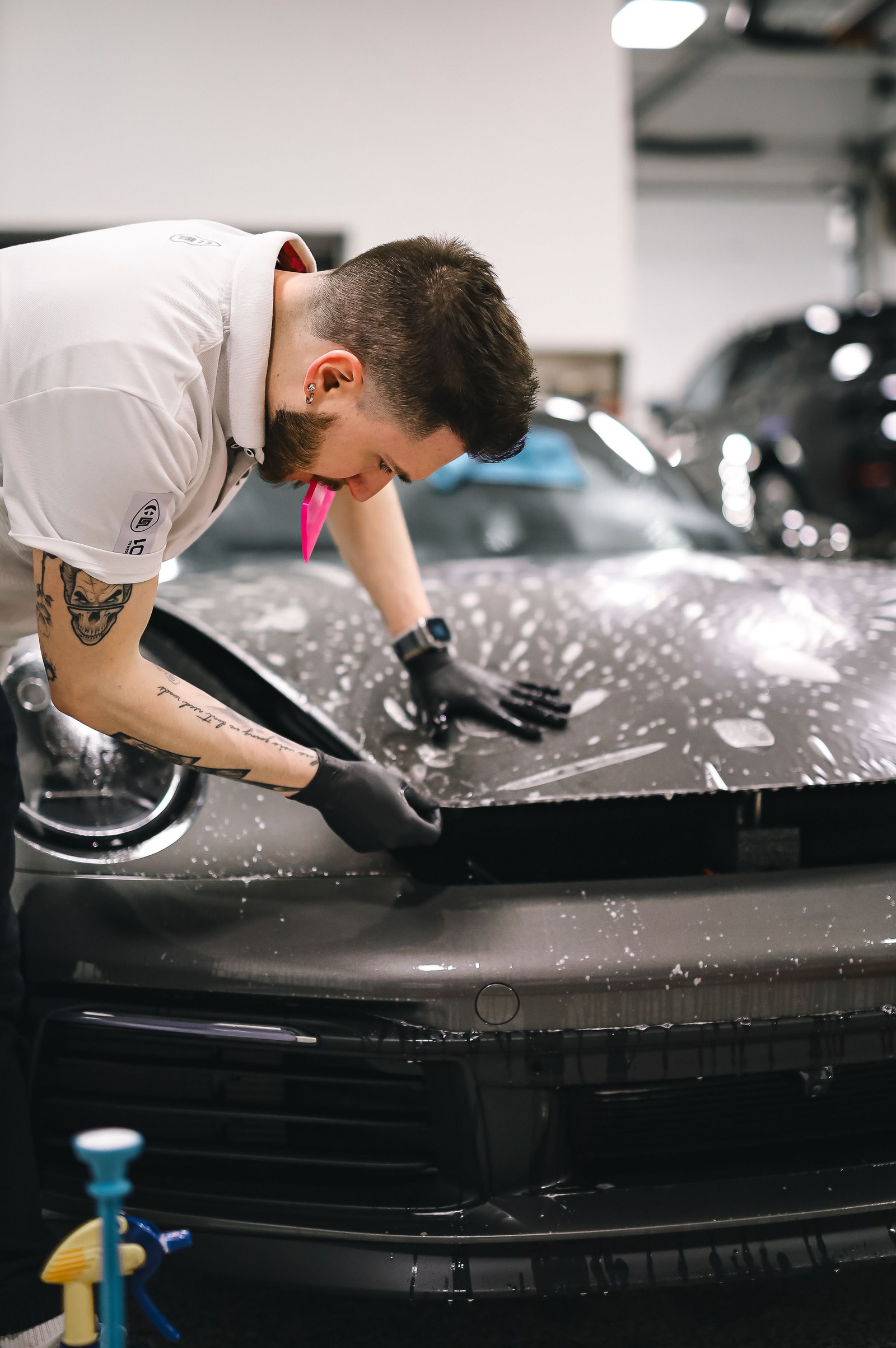 Detailer applying paint protection film to a sports car